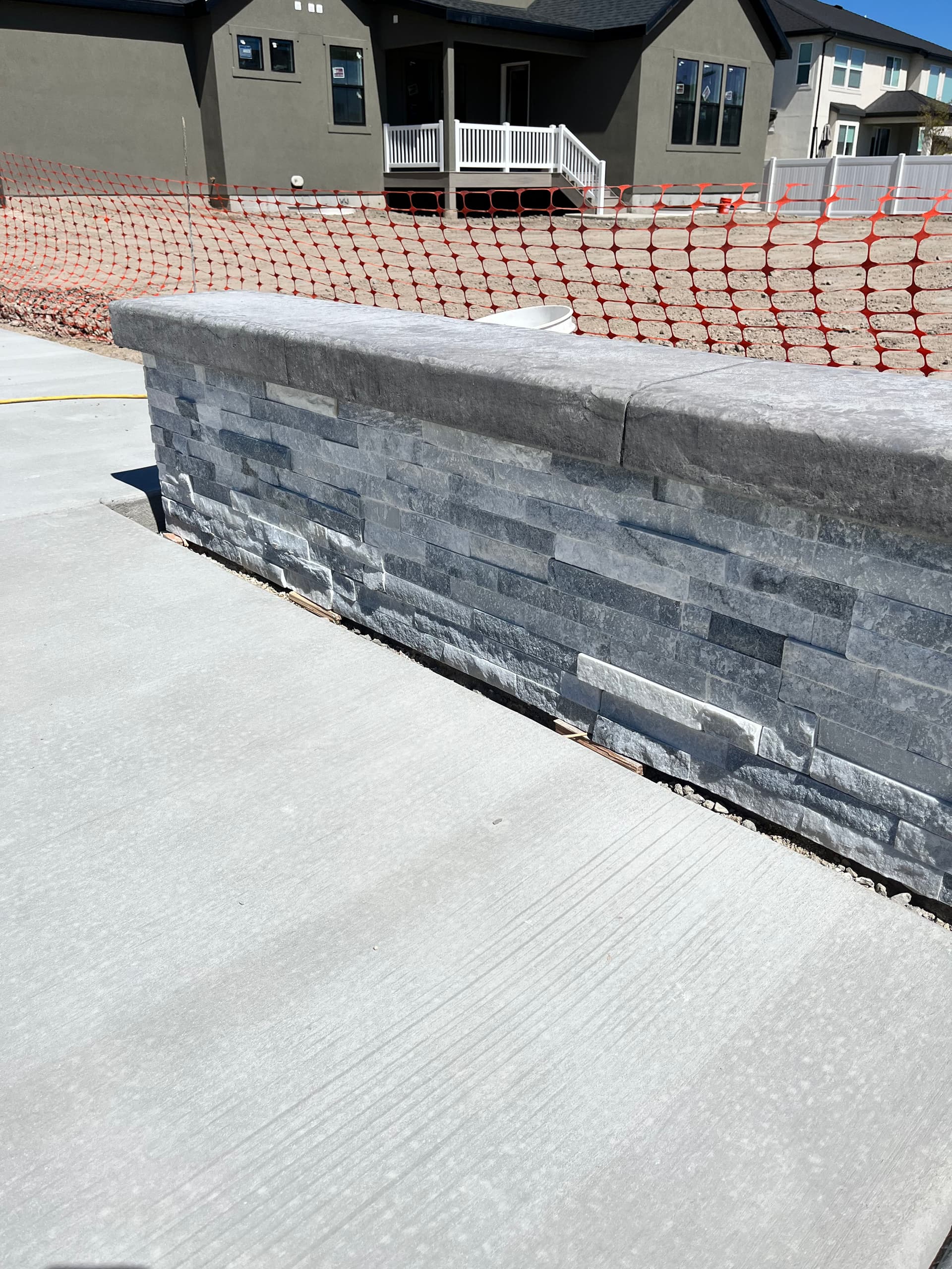 Custom Retaining Wall with Stone Veneer and Stamped Concrete Cap image