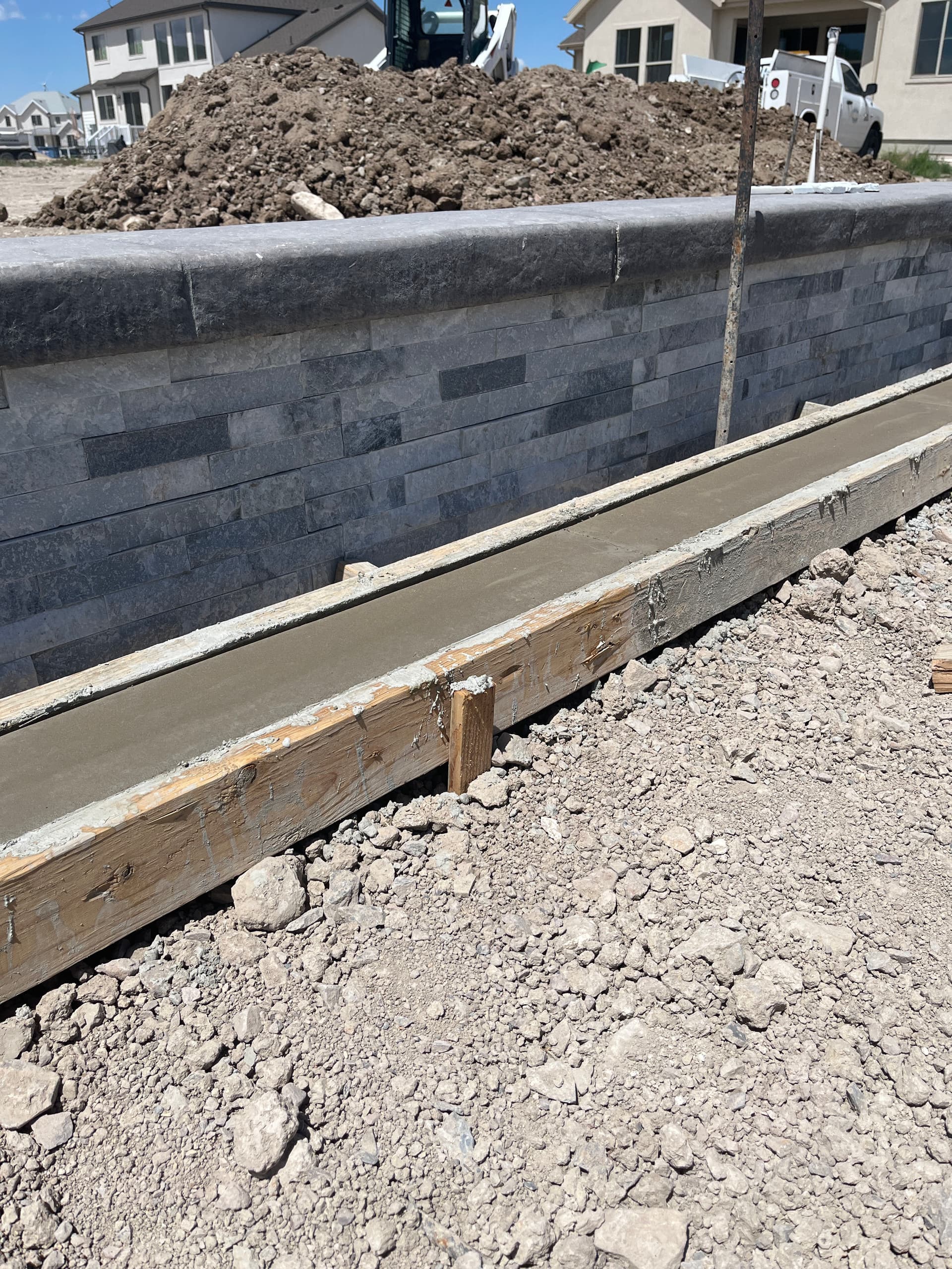 Concrete Curbing Ties Pool Decking Into Stone Retaining Wall image